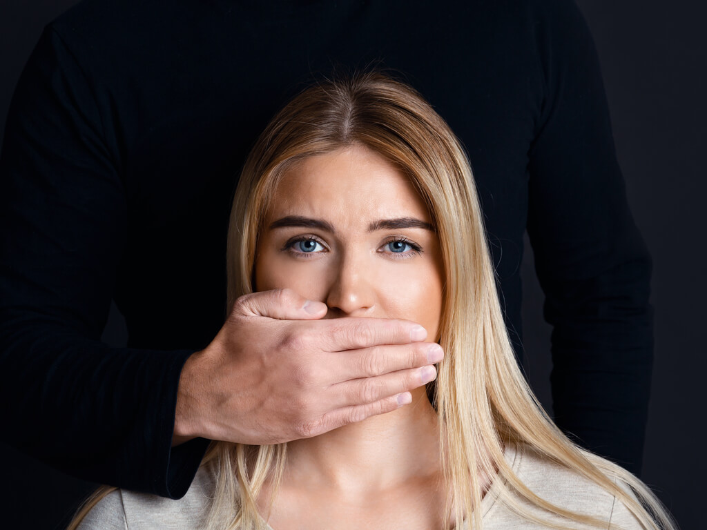woman being silenced by a hand