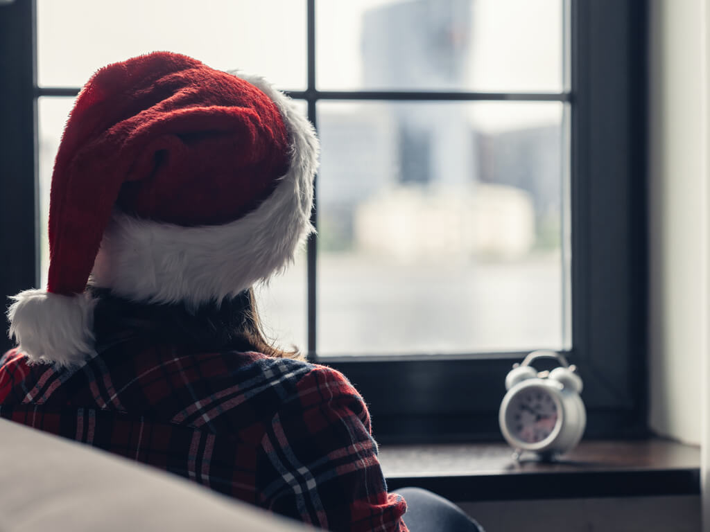 person sitting alone in a santa hat