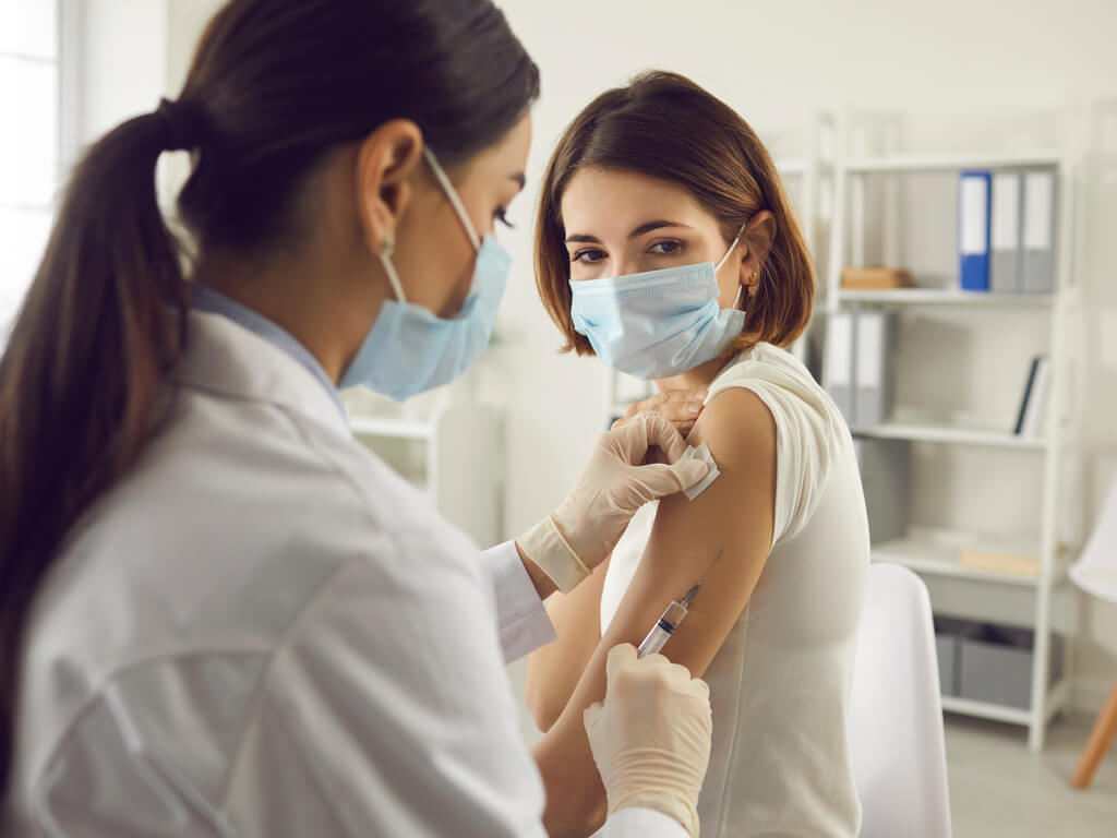 woman in a medical facility receiving a vaccine - COVID-19 Vaccinations