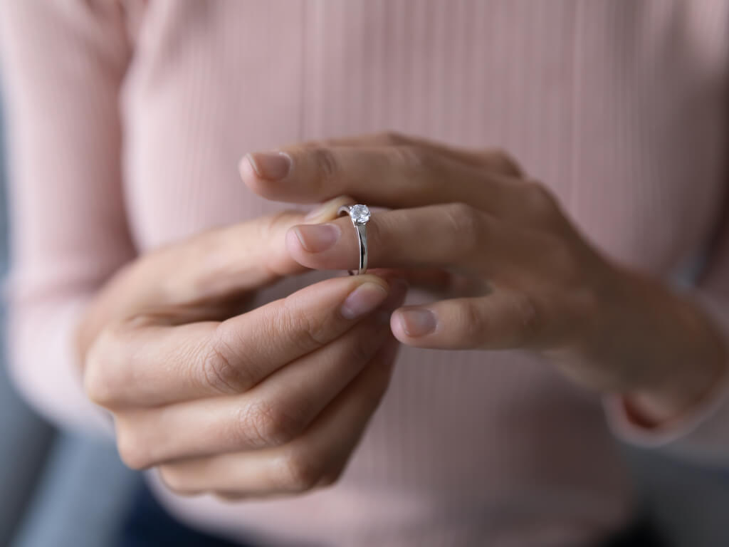 woman taking off her engagement/wedding ring