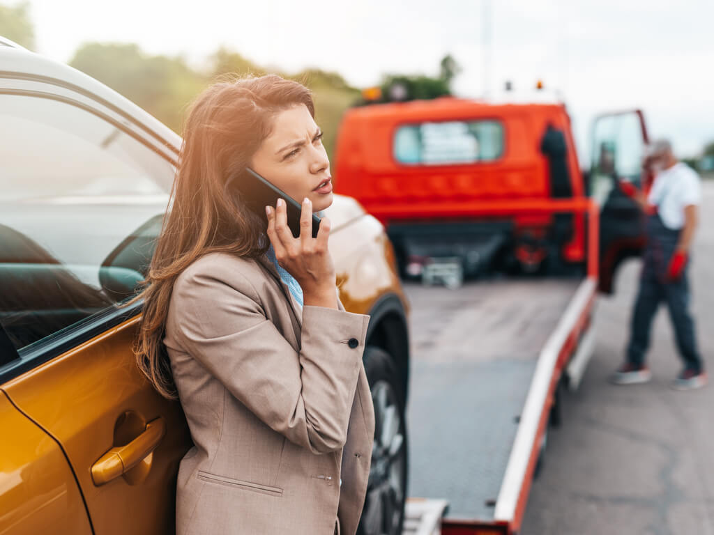 a woman on the phone calling for a tow truck