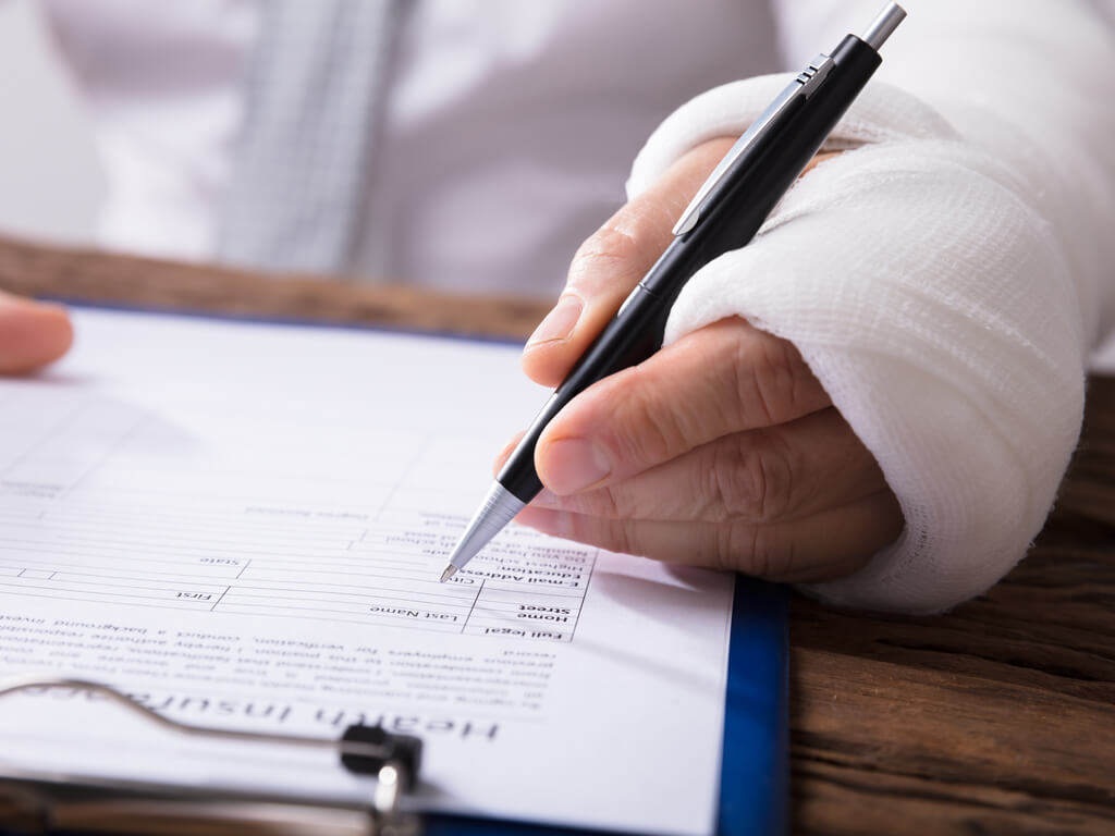 man with injured arm filling out paperwork
